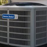 Seasonal illustration of an outdoor condensing unit surrounded by spring flowers for Greenwich HVAC maintenance guidance.