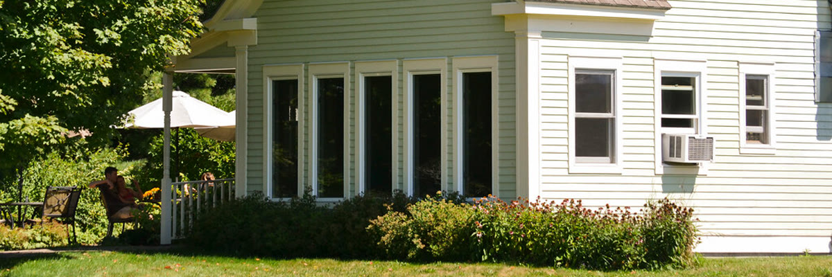 Suburban house with lawn and flowers on a summer day in Greenwich, CT